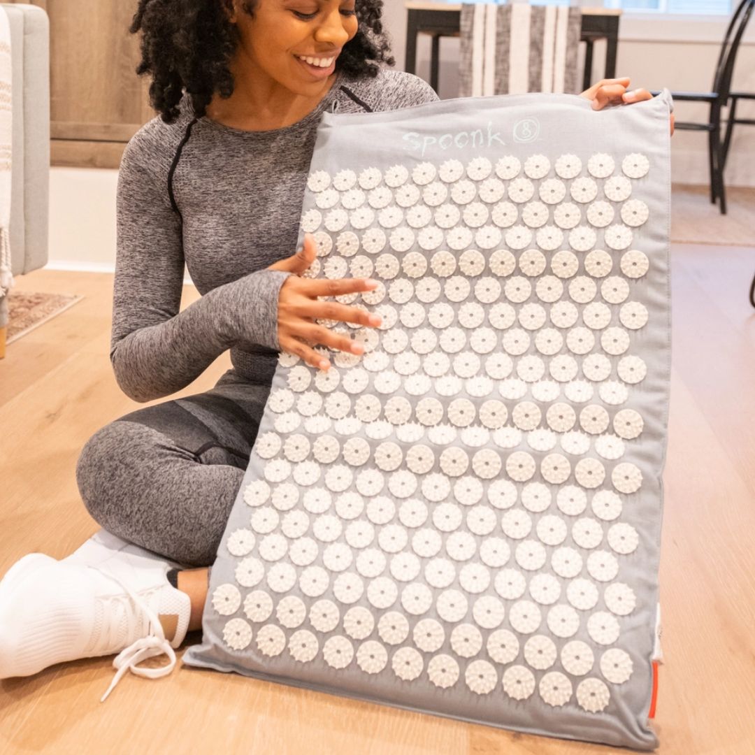 Woman holding acupressure mat