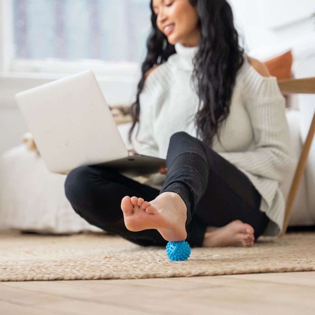 Rolling acupressure ball on heel of foot