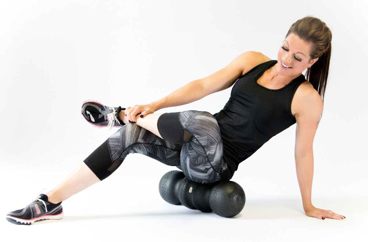 Woman rolling hip on foam roller