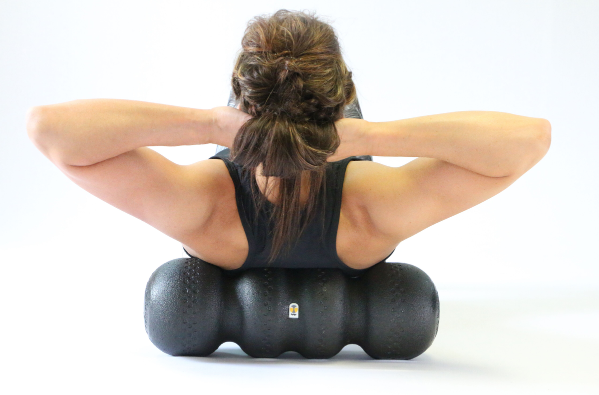 Woman rolling upper back on foam roller
