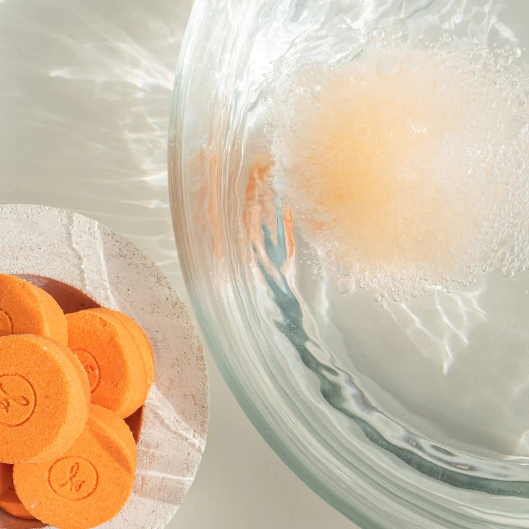 Orange bath fizzy dissolving in water