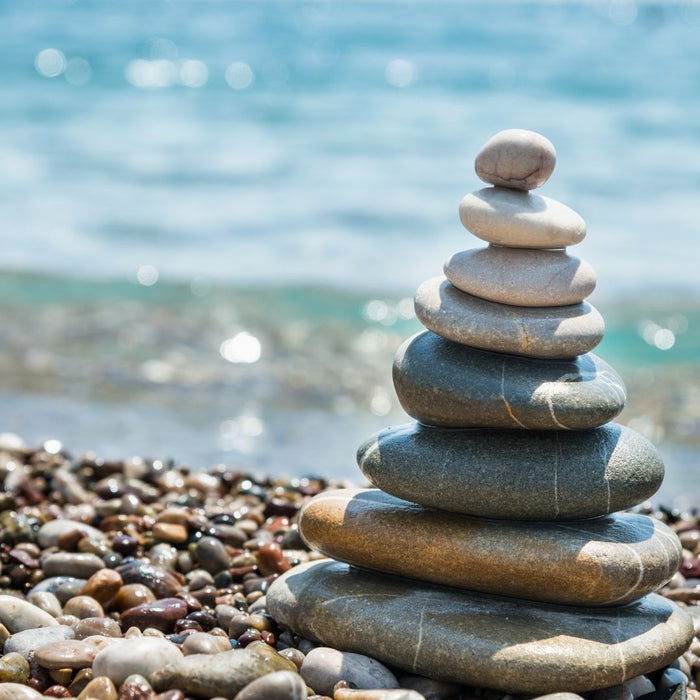 Rocks stacked in front of water