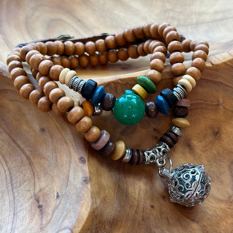 Natural wood bead wrap bracelet adorned with natural color beads and a silver cage charm with lava rock for essential oils