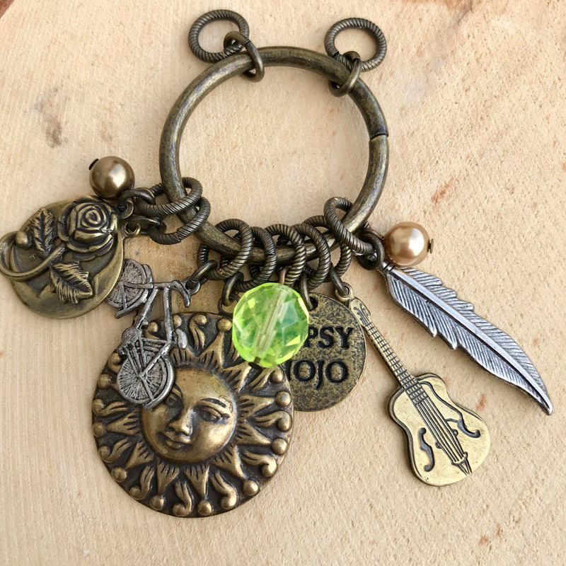 Antique brass Gypsy Mojo pendant with rose, bicycle, sun, guitar, feather, and colored bead charms
