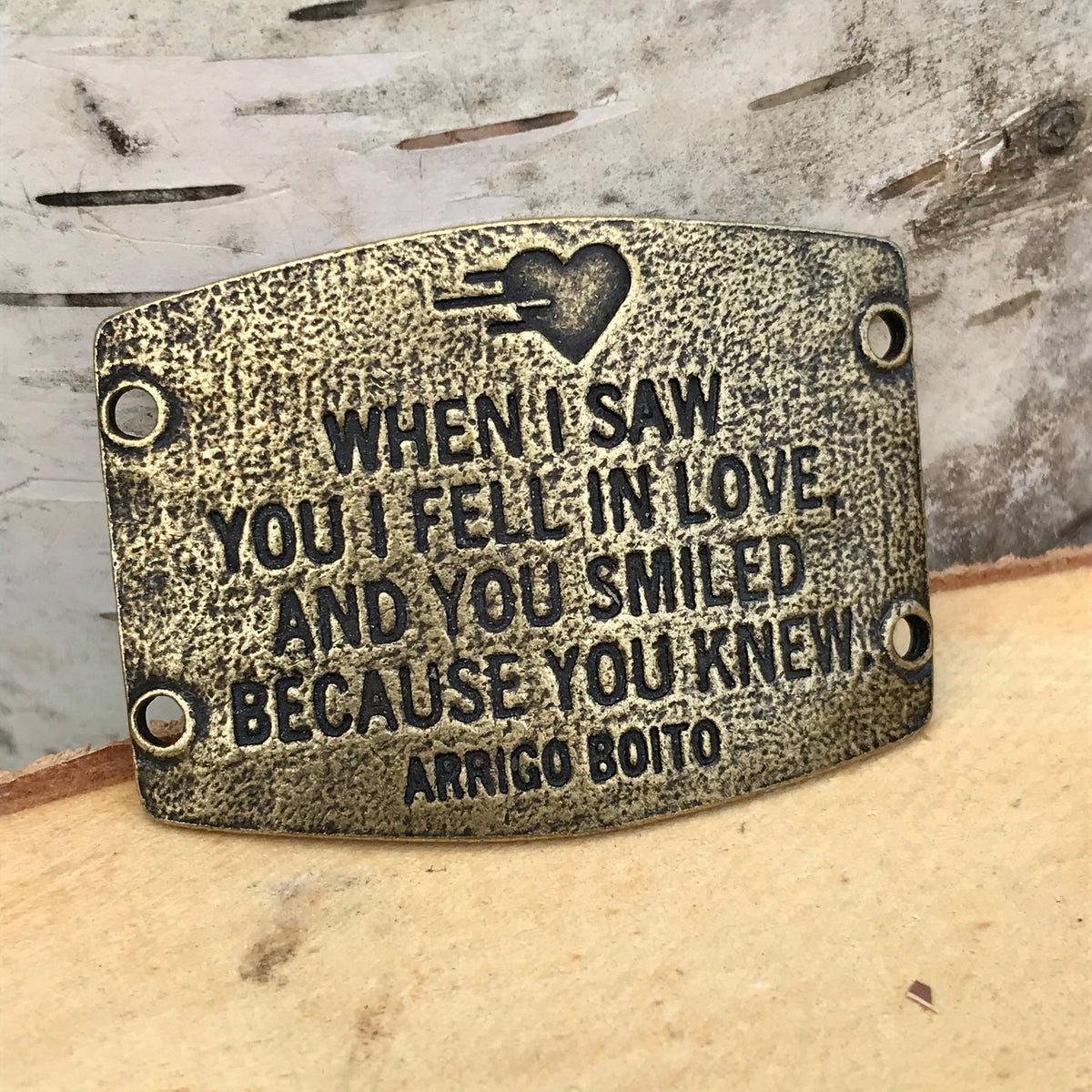 Antique brass finish Lenny & Eva bracelet sentiment that reads, "When I saw you I fell in love, and you smiled because you knew." Quote by Arrigo Boito. A heart etching is above the quote.