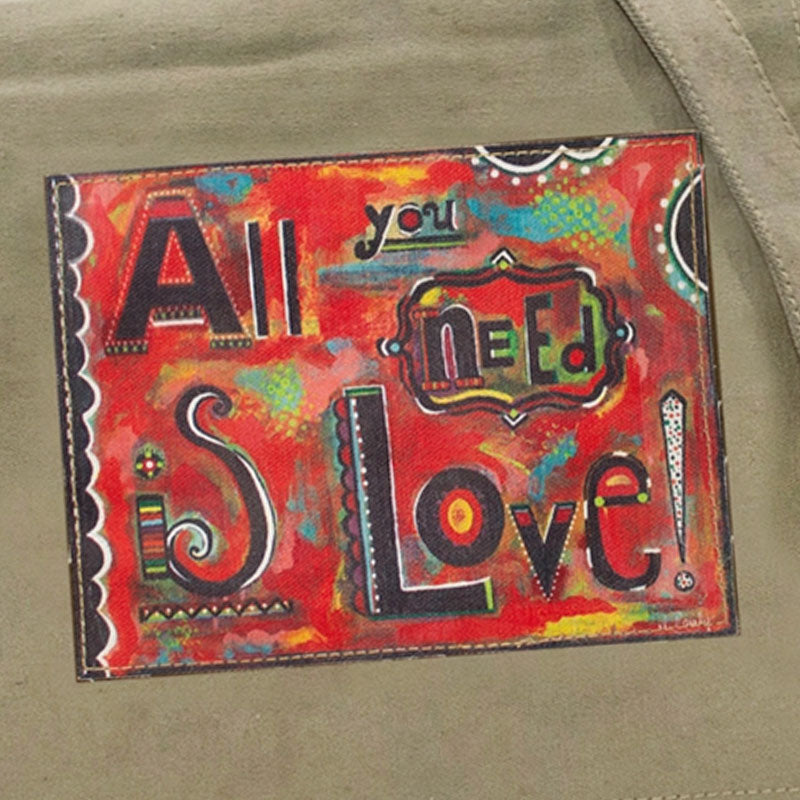 Closeup of the brightly colored "All you need is Love!" patch on the flap of the crossbody bag made of recycled military tents.