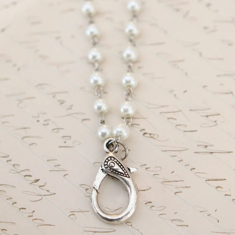 White pearl necklace with a silver lobster clasp to add charms to