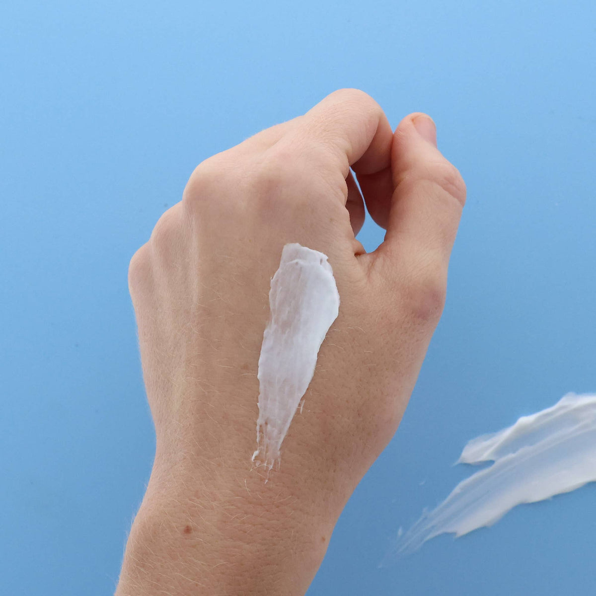 Image of hand with a sample of the thick body spread lotion on it