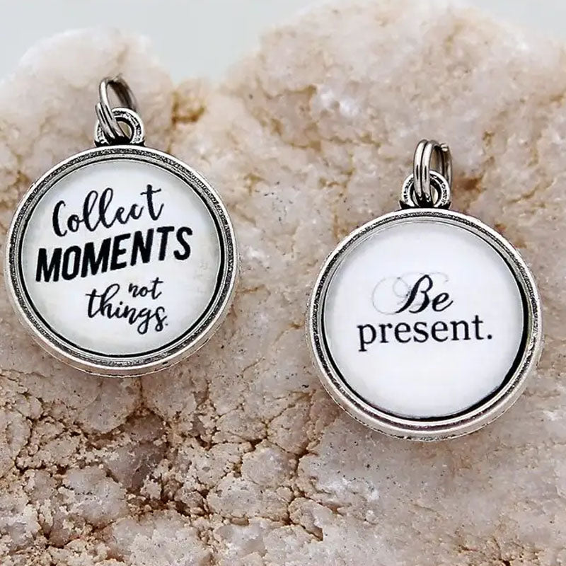 Necklace pendant with the text "Be Present" on one side and "Collect moments not things." on the other side