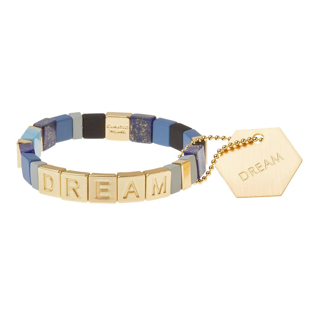 Bracelet with square chunky beads in shades of blue, black, greyish blue, and gold. Gold beads spell out DREAM.