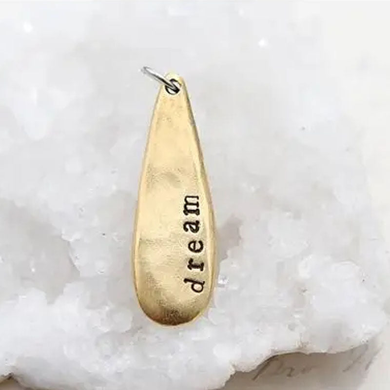 Gold teardrop shaped necklace pendant stamped with "dream"