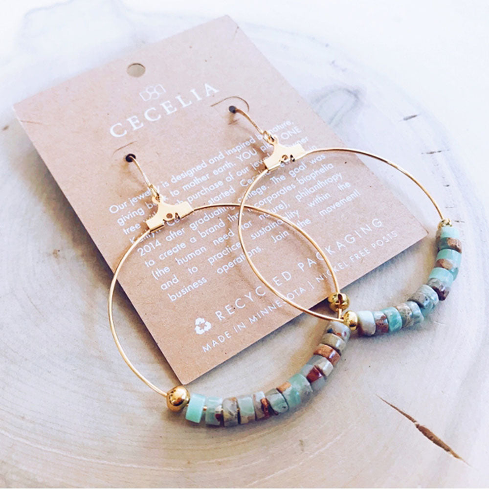 Gold earrings with turquoise, coral, and tan colored serpentine turquoise beads on a gold hoop