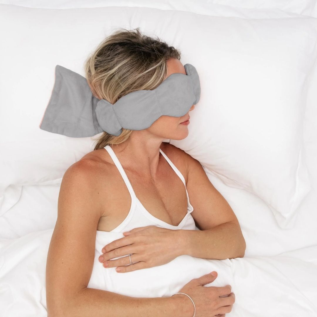 Woman sleeping on her side with gray weighted eye pillow