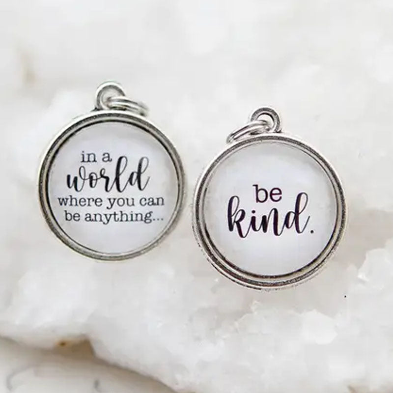Necklace pendant that reads "in a world where you can be anything..." and the other side says "be kind."