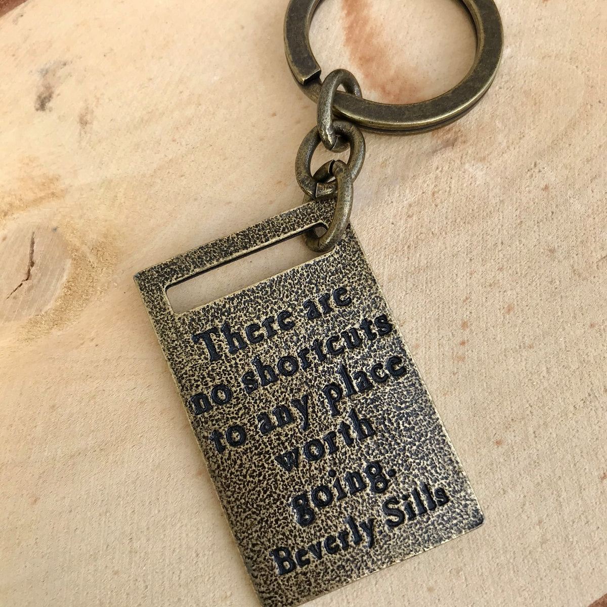 Antique brass finish keychain with the quote "There are no shortcuts to any place worth going."