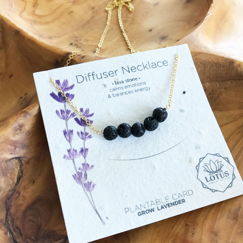 Gold filled necklace with black lava rocks for essential oil aromatherapy. Made in the U.S.A. by Lotus Jewelry Studio. Jewelry card contains lavender seeds and can be planted.