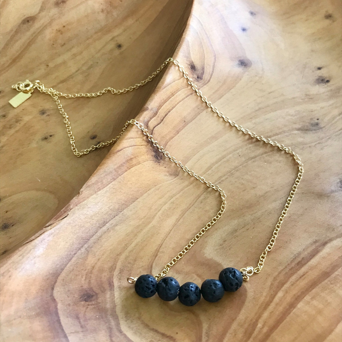 Gold filled necklace with black lava rocks for essential oil aromatherapy. Made in the U.S.A. by Lotus Jewelry Studio.