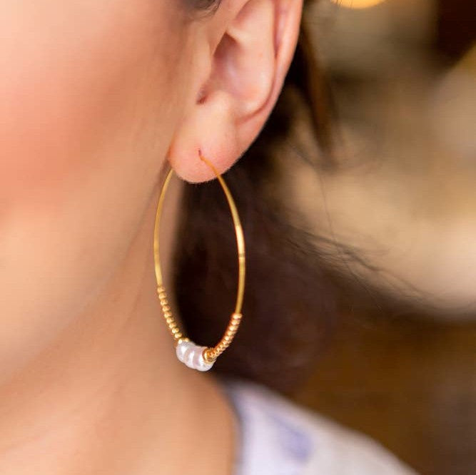 Large gold hoop earring with tiny gold beads and 3 pink rose quartz beads