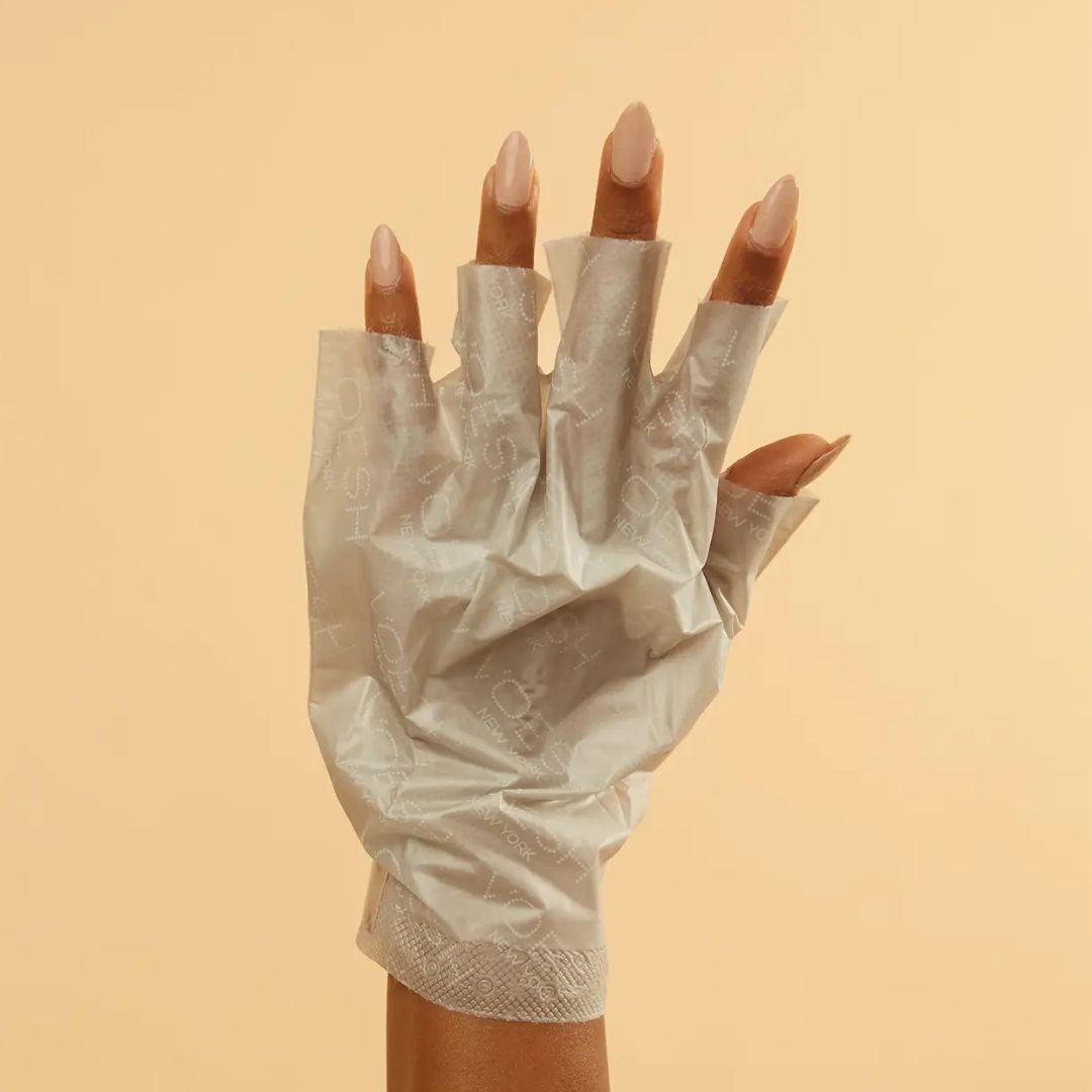 Collagen gloves on hands with fingertips of gloves removed for manicure