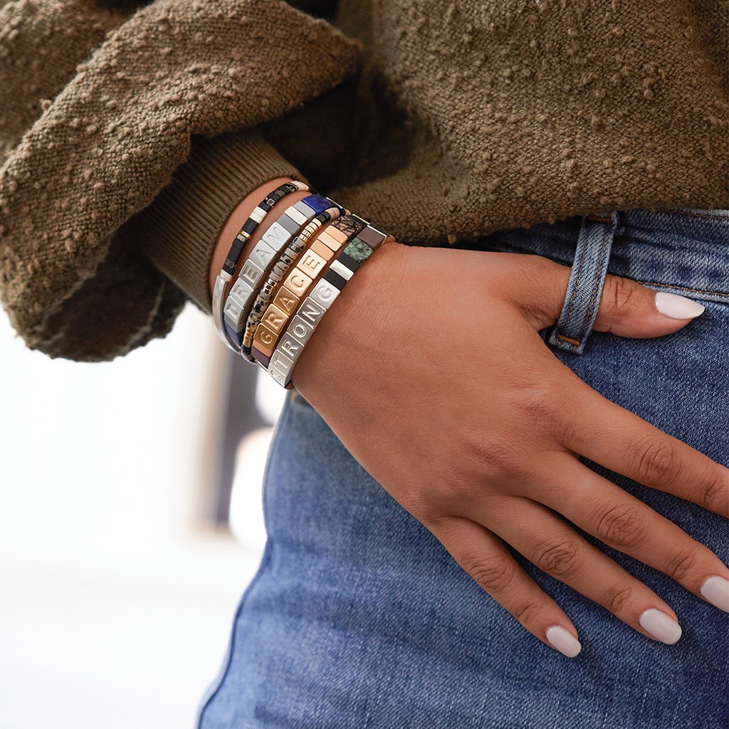 Model wearing a stack of Empowerment and Good Karma bracelets by Scout Curated Wears