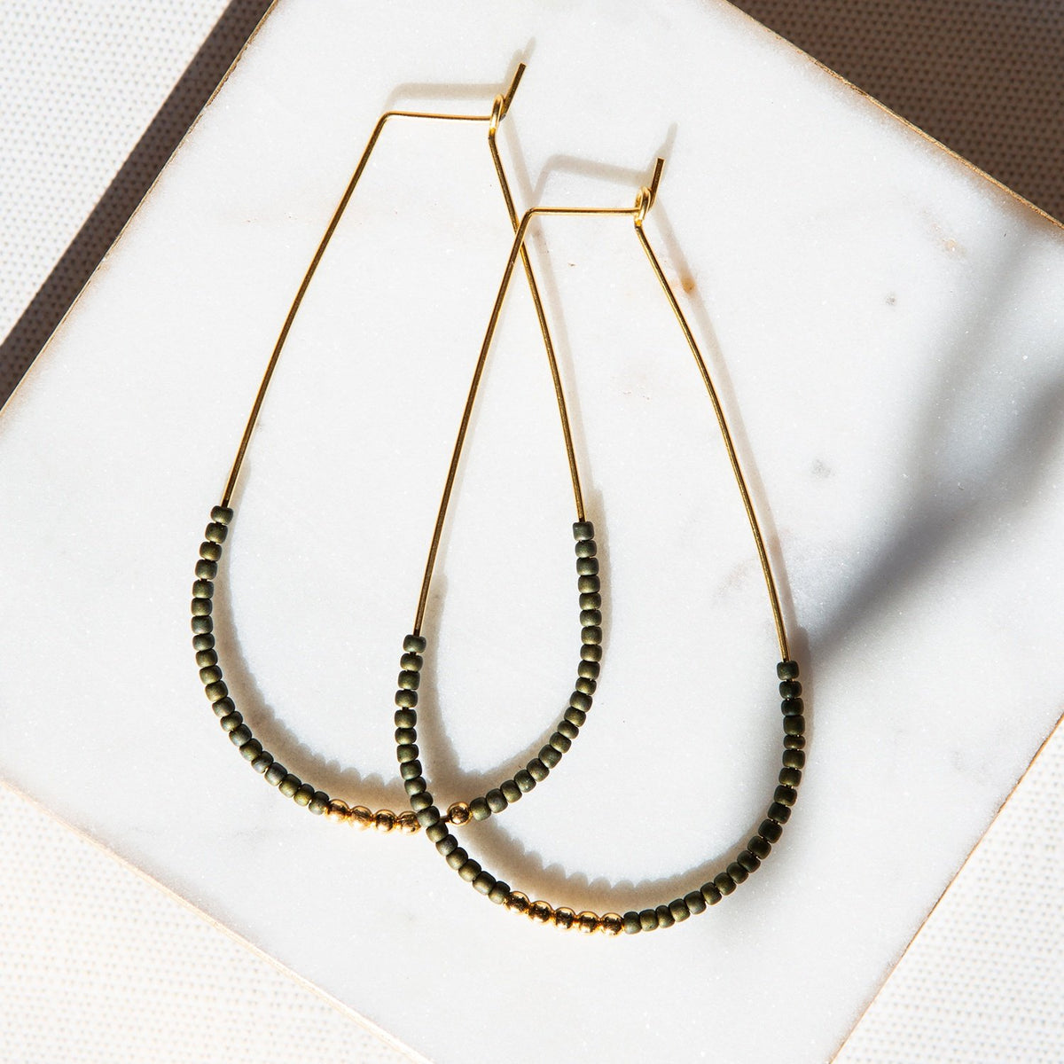 Delicate gold wire earrings with tiny olive green accent beads. Scarlett style by Lenny & Eva Jewelry.
