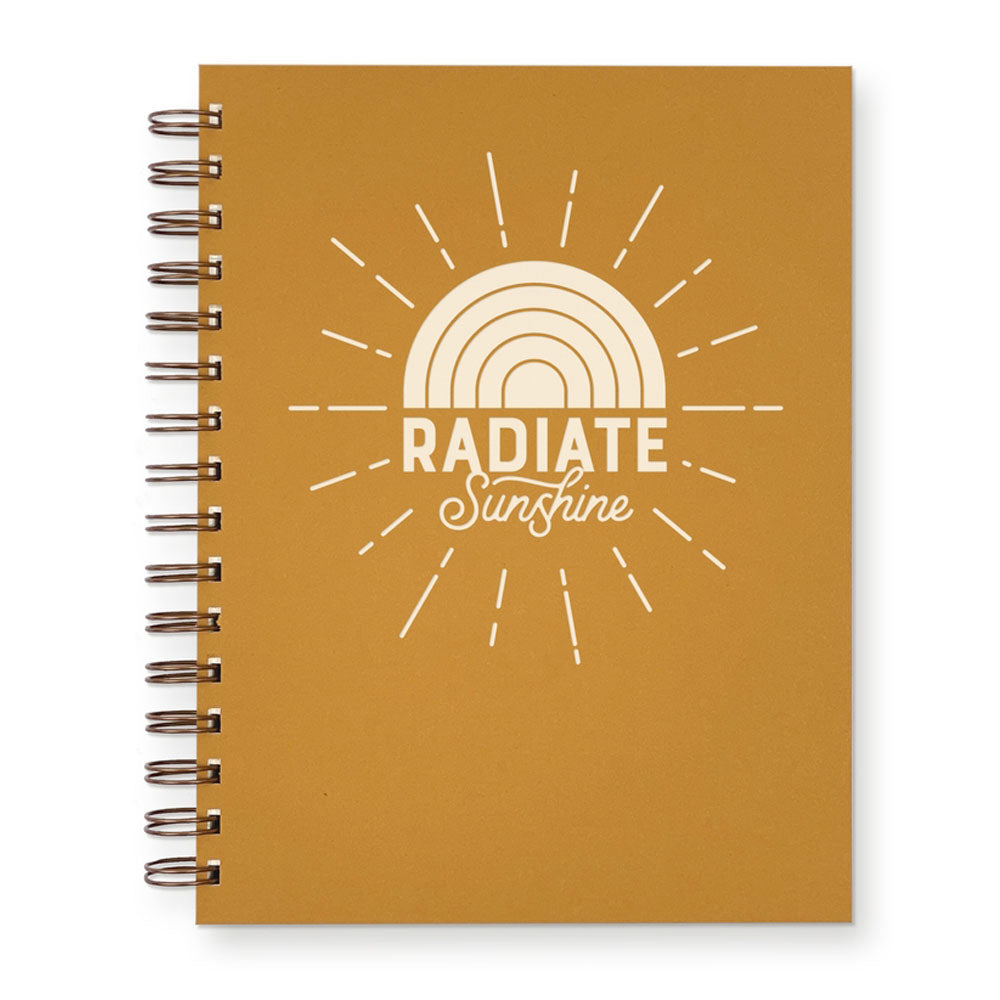 Saffron yellow journal with "Radiate Sunshine" and a drawing of the sun on the cover. The side is spiral bound.
