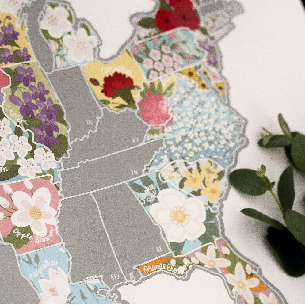Close up of scratch off map with several state flowers revealed.