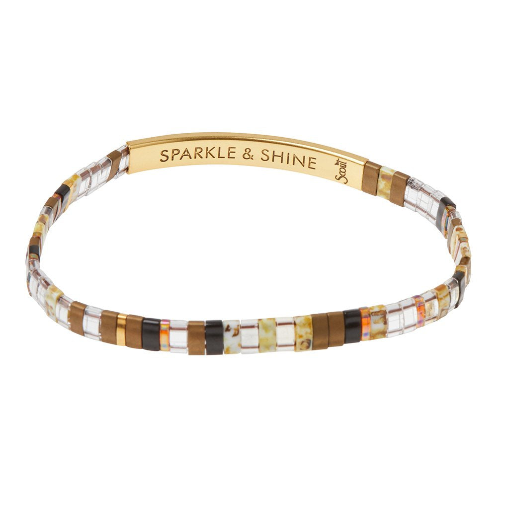 Bracelet in shades of browns, tortoise, clear, and gold beads with a gold band that says "SPARKLE & SHINE"
