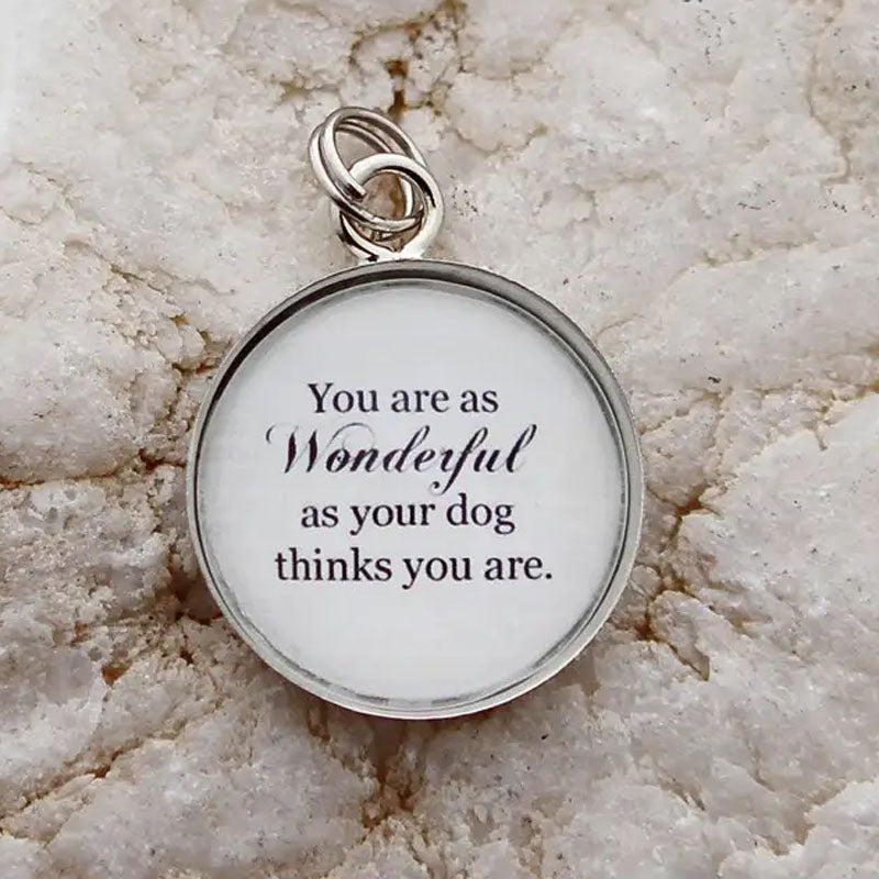 Round white pendant that reads, "You are as Wonderful as your dog thinks you are." The edge of the pendant is silver.