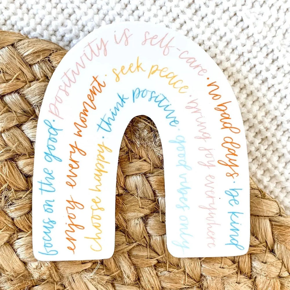 Rainbow shaped sticker with several positive thoughts printed in earthy pastel colors.