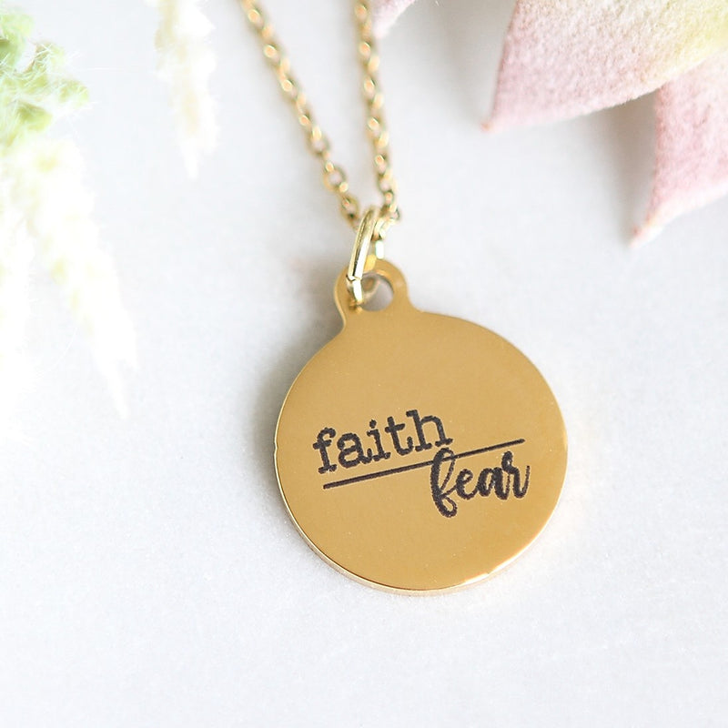 Gold pendant engraved with "Faith over Fear"