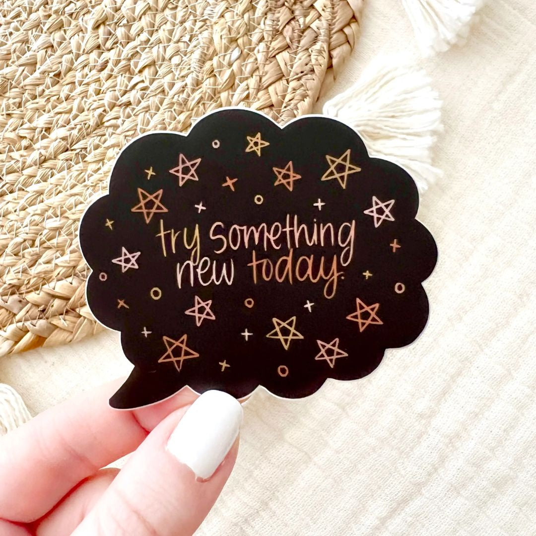 Black text bubble sticker with stars by Elyse Breanne Designs. "Try something new today"